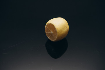  slice of lemon with reflection on a black background