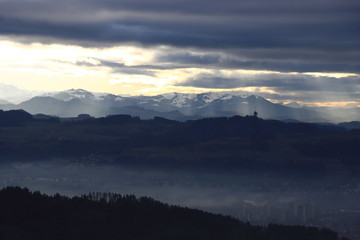 Fototapeta na wymiar City of Bern in the fog. Gurten and Gantrisch mountain in the background.