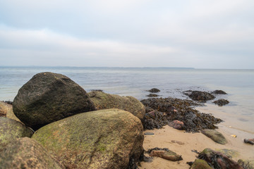 Wonderful view of a beach  with many stones on and in the water