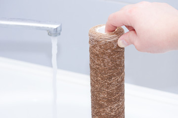 Dirty water filter cartridge used. Domestic water osmosis system at kitchen. Ecology, clean water,...