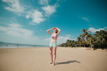 Fototapeta na wymiar Girl on a sandy beach with palm trees
