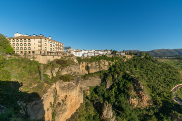 Fototapeta na wymiar ronda village at the edge of cliffside with trees and white houses against sky, Andalusia, Spain