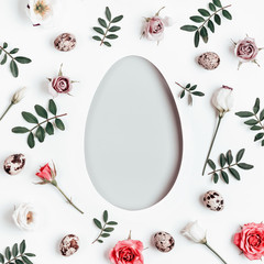 Happy easter concept. Creative layout with floral pattern and quail eggs. Egg shaped hole with copy space