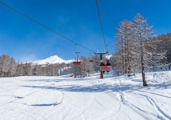 Fototapeta na wymiar Bardonecchia, Italian Alps, snowy scenery: ski slopes and chairlift (chair lift), ski resort and winter snow landscape. Photos with Snow
