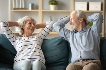 Old couple relaxing on sofa take break enjoy retired life