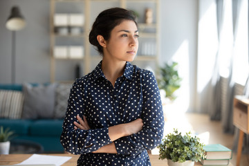 Serious confident indian woman looking away dreaming of success