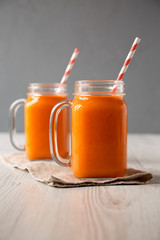 Homemade Mango Carrot Smoothie in glass jars, side view.