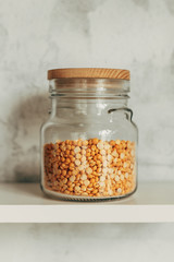 Yellow peas in a vintage glass jar on a kitchen shelf