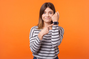 Portrait of impatient positive woman with brown hair in long sleeve striped shirt standing,...