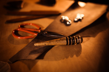 Working process of the leather belt in the leather workshop. Tanner in old tannery. Crafting tool...