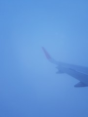 Fototapeta na wymiar Airplane wing in the fog