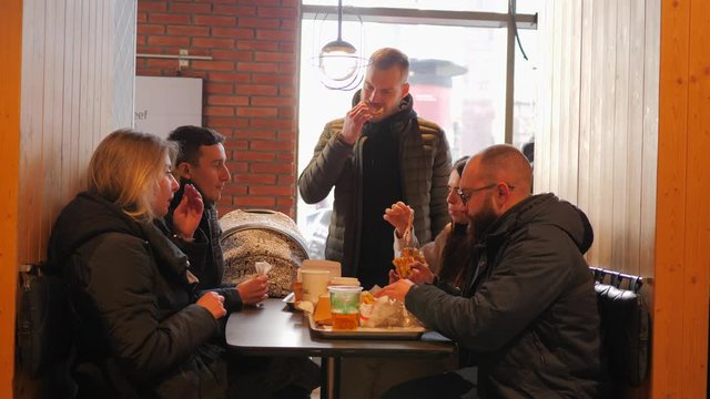 Hang out guys friends eat in fast food restaurant hamburgers french fries potatoes and chicken nuggets drinking alcohol beer