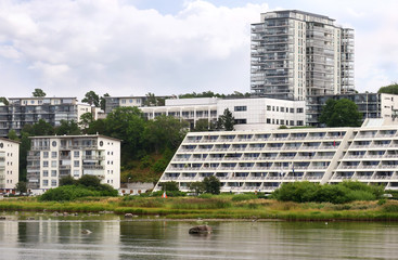 Fototapeta na wymiar Modern apartment complexes located next to the sea with lush nature on their doorstep