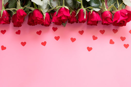 Border of red roses and hearts on a pink background - valentines day concept