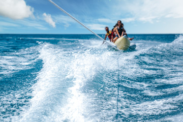 A group of people enjoing the banana riding. water sport concept  - Powered by Adobe