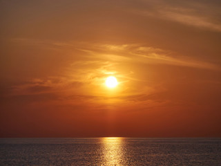 Fototapeta premium Yellow orange Sunset on sea or ocean, beach coast. Alone man on sunset beach on land.