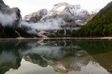 Lago di Braies or Lake Braies in the Dolomites. Lake is surrounded by mountains reflected in the water. Boats are floating on the water surface. 1st point of Alta Via 1 trail. Italy, South Tyrol. 
