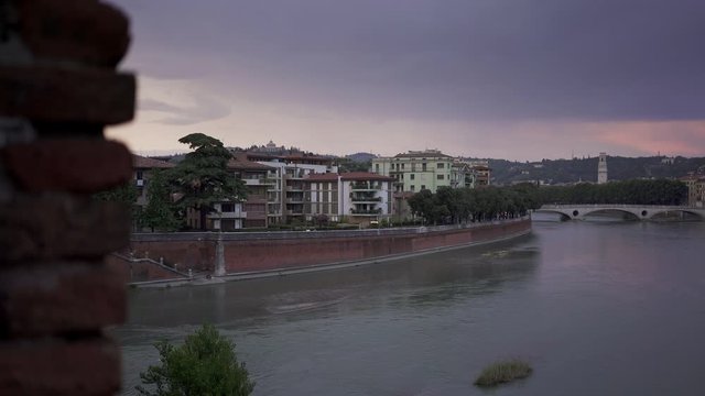 View of Bridge of the Victory in old city of Verona under cloudy grey sky in summer. Pan shot left to right view on Verona and the bridge