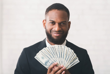 Young successful black businessman holding money over white backgrpund