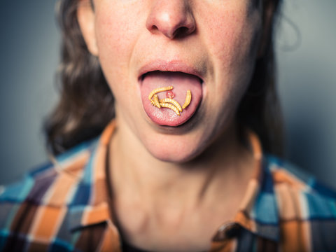 Woman with edible worms on her tongue