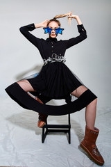 girl in beautiful modern clothes posing in the Studio with objects, mannequin