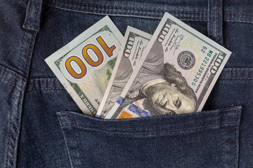 Many dollar 100 banknotes in a back jeans pocket