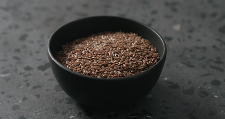 flaxseed in black bowl on terrazzo countertop with copy space
