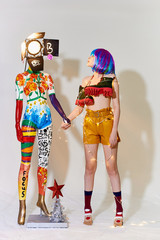 girl in beautiful modern clothes posing in the Studio with objects, mannequin