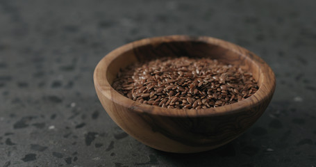 flaxseed in olive bowl on terrazzo countertop with copy space