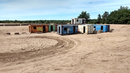 Shipping containers in sand with tracks