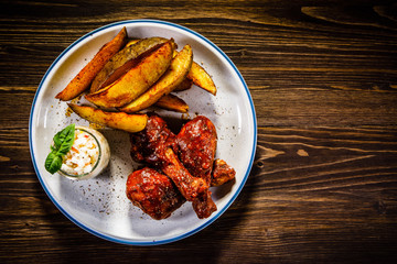 Barbecue chicken drumsticks with baked potatoes and coleslaw