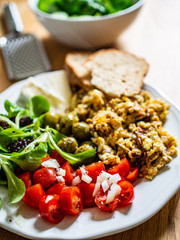 Breakfast - scrambled eggs with vegetables and toasts