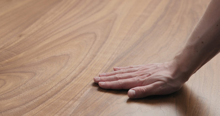 man hand touches black walnut dining table surface