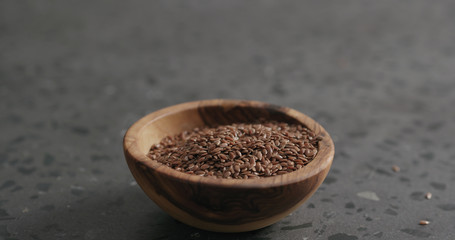 flaxseed in olive bowl on terrazzo countertop with copy space