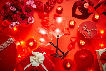Fototapeta na wymiar Valentines day romantic decoration with roses, wine glasses, boxed gifts, candles