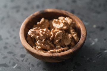 Walnuts in wooden bowl on terrazzo countertop