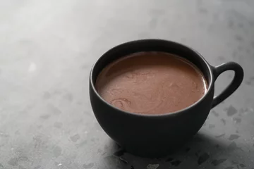 Deurstickers simple cup of hot cocoa drink on terrazzo background © GCapture