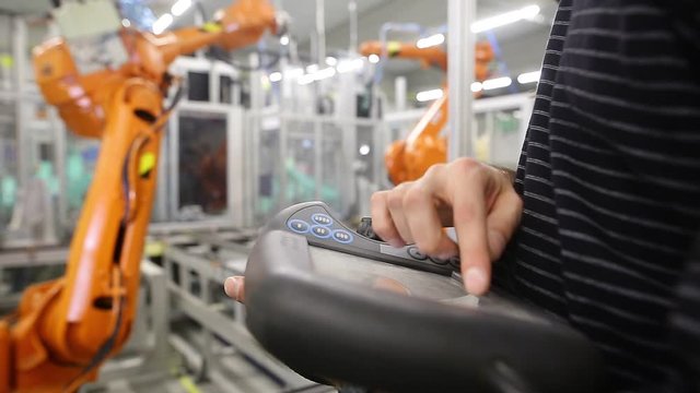 Man programming robot in automotive industrial, professional programmer, industry concept