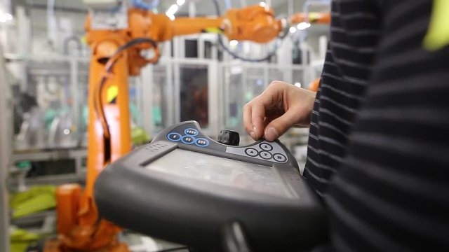 Man programming robot in automotive industrial, professional programmer, industry concept