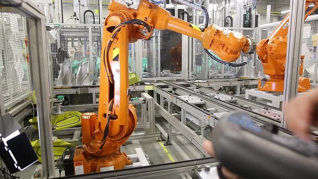Man programming robot in automotive industrial, professional programmer, industry concept