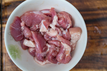 Fresh pork meat in white bowl.