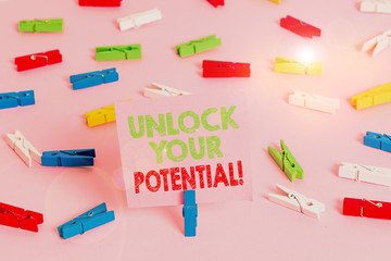 Text sign showing Unlock Your Potential. Business photo showcasing release possibilities Education and good training is key Colored clothespin papers empty reminder pink floor background office pin