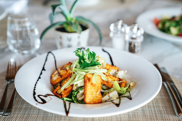 A delicious hellumi cheese salad is served in a elegance restaurant or hotel