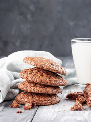 Brownie cookies on a wooden table with milk. Copy space.