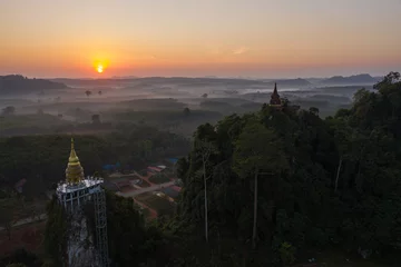 Fotobehang Beautiful sunrise with pagoda on the top of rock and tree with fog at Khao Na Nai Luang Dharma Park,Surat thani province,Thailand © Sathit Trakunpunlert