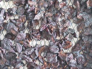Black bars from a home-made dryer of fruits and vegetables with dried plums.