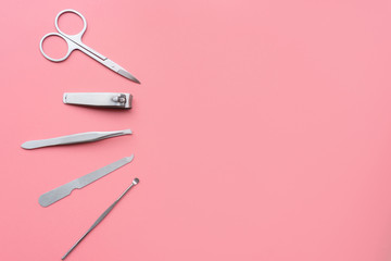 Set of manicure instruments and tools on pink background, top view, copy space