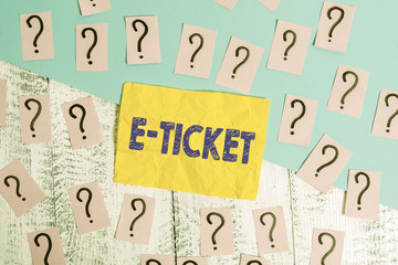 Writing note showing E Ticket. Business concept for Digital ticket that is as valid as a paper ticket or its equivalent Scribbled and crumbling papers with thick cardboard above wooden table