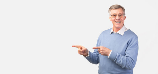 Elderly Man Pointing Fingers Aside Standing Over White Background, Panorama