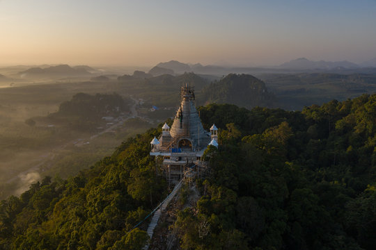 Beautiful sunrise with pagoda on the top of rock and tree with fog at Khao Na Nai Luang Dharma Park,Surat thani province,Thailand